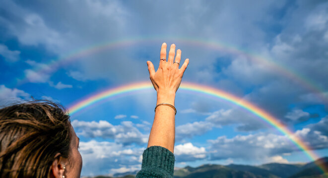 虹に向かって手を伸ばす女性 | A woman reaching out her hand towards a rainbow Generative AI