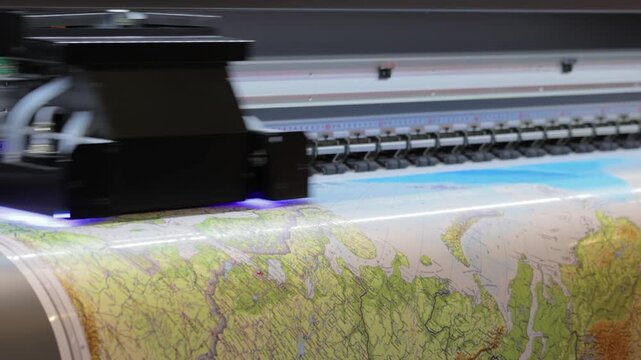 Industrial large format uv inkjet printer printing detailed geographical map on vinyl roll.