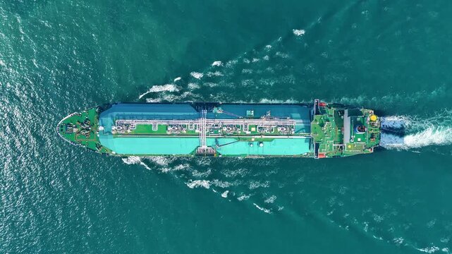 LNG tanker ship sailing in the open ocean. Liquefied Natural Gas carrier vessel with white spherical tanks transporting energy fuel. freight transportation shipping Global gas supply logistics.