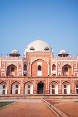Naklejka premium Elegant vertical photograph of Humayun’s Tomb in New Delhi, India, featuring its iconic white marble dome, red sandstone facade, ornate arches, and perfectly symmetrical Mughal architecture