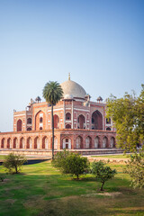 Obraz premium Beautiful vertical view of Humayun’s Tomb in New Delhi, India, surrounded by lush gardens, palm trees, and landscaped grounds beneath a clear blue sky. The iconic UNESCO World Heritage Site