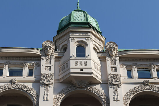 Art Nouveau building facade with decorative sculptures and green dome in Belgrade.