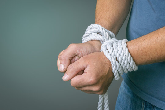 Bound By Addiction And Dependency Concept.Hands tied with rope symbolizing addiction, dependency, loss of control, compulsive behavior, mental health struggles, recovery, and the desire for freedom.