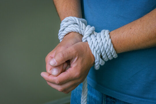 Bound By Addiction And Dependency Concept.Hands tied with rope symbolizing addiction, dependency, loss of control, compulsive behavior, mental health struggles, recovery, and the desire for freedom.