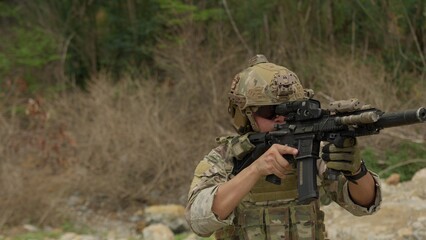 Fototapeta premium A special forces soldier aims his rifle during a tactical training exercise in a rugged outdoor environment, demonstrating precision and combat readiness.