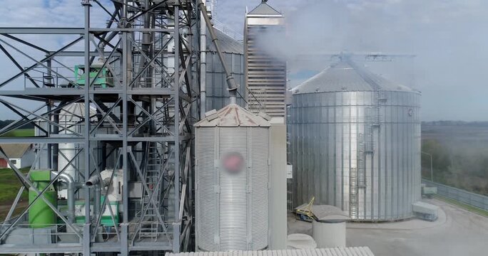 Industrial grain elevator complex with steam release during agricultural processing and storage operations.