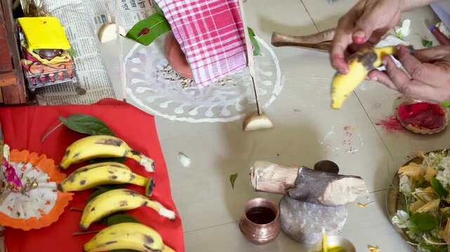 Hindu Brahmin doing the Yajna or puja, A pooja thali with a lamp, flowers, a coconut, a copper pot, incense sticks, banana. Concept of Hindu worship at home.