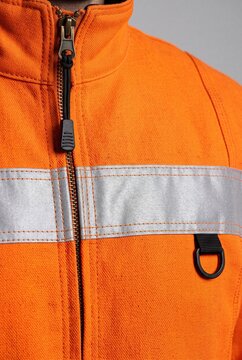 High visibility orange safety jacket with reflective stripes close up