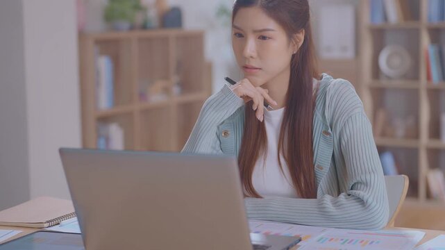 Smiling asian business woman using tablet laptop with equipment placed for doing finance on an home office desk, tax, report, accounting, statistics, thinking and analytical research concept.