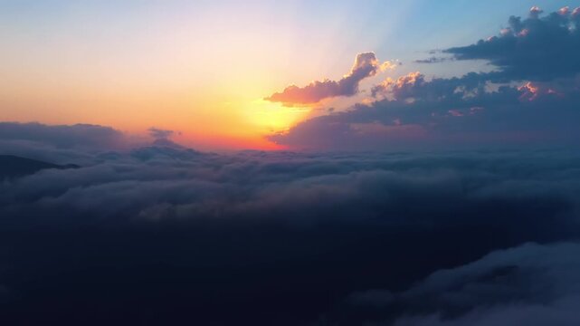 Stunning aerial view of sunrise over a thick layer of soft clouds during a beautiful morning horizon.
