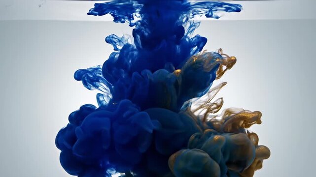 Blue and gold ink drops colliding and swirling in clear water creating abstract fluid shapes, dynamic movement, beautiful cloud formation