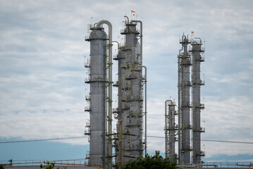 Fototapeta premium Oil refinery distillation column industrial plant petrochemical pipeline steel tower processing unit chemical industry under cloudy sky, complex infrastructure for fuel production