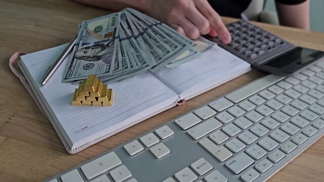 Money counting on a desk with a calculator and notes in a simple workspace during daytime