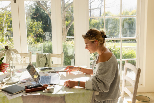 young woman artist doing watercolor drawing in her studio