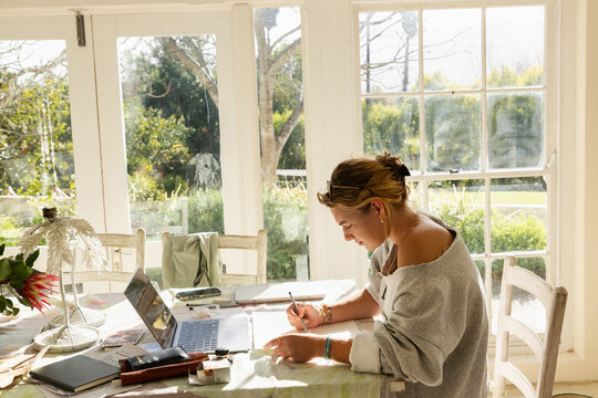 young woman artist doing watercolor drawing in her studio