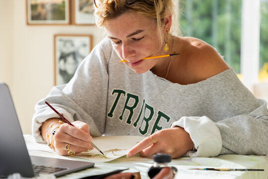 young woman artist working on a watercolor drawing in her studio