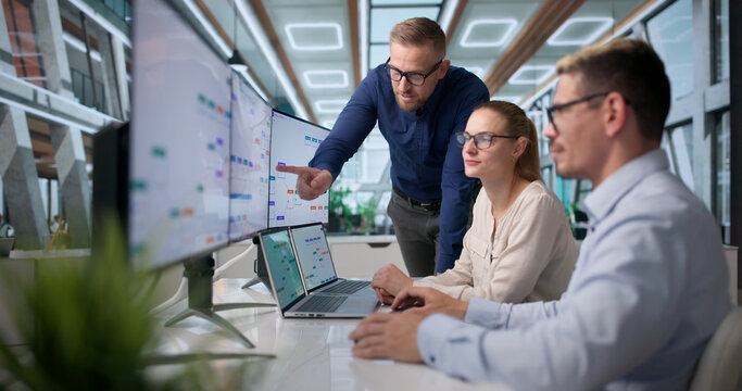 Project Manager Leads Diverse Team Using Laptop