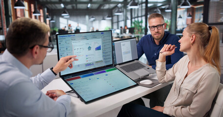 Naklejka premium Diverse Team Reviews Compliance Data Together Using Laptop