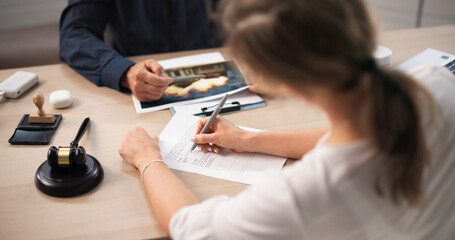 Fototapeta na wymiar Insurance Agent And Client Review Claim Forms During Property Damage