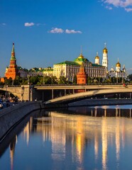Obraz premium Golden domed Russian cathedral by river at sunset.
