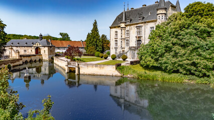 Fototapeta premium Aerial drone view of historic Schaloen castle surrounded by water moat, green gardens and beautiful nature landscape, Limburg, the Netherlands