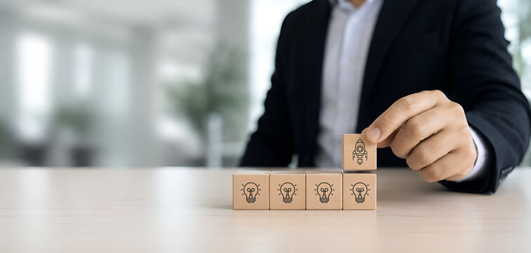 Idea creation and innovative product launching concept. Wooden block with rocket and idea generation icons. Idea creation, innovation and the launch of a new product from concept to execution. 
