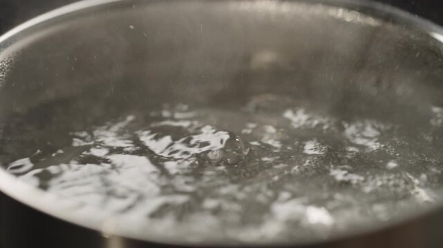 Close-up of boiling water in stainless steel pot on stovetop