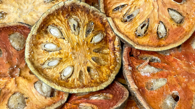 A close-up of dried bael (matum) slices, with the texture of the pulp and seeds clearly visible. A natural ingredient for making herbal teas, infusions, and healthy drinks.