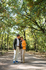 Fototapeta premium Senior couple walking in park enjoying nature together