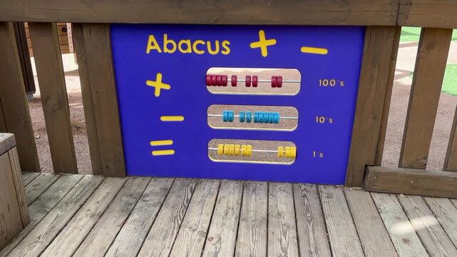 Blue abacus panel with colorful sliding beads mounted on wooden playground deck for educational play