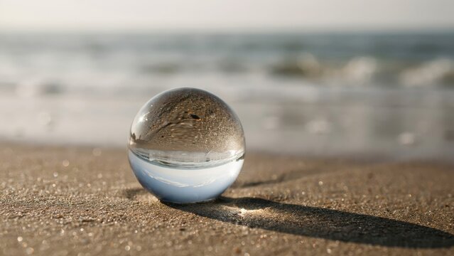 Creative Glass Lensball on a Sandy Beach Reflecting the Ocean Landscape