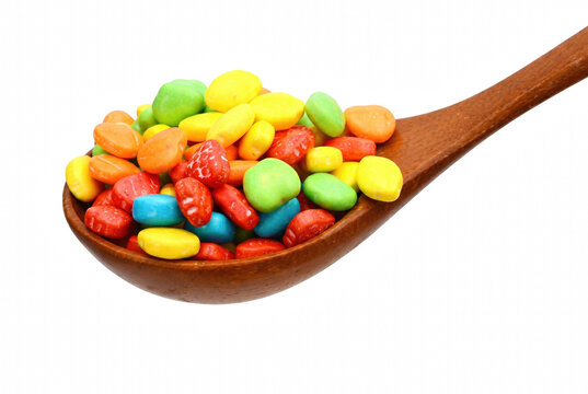 Wooden spoon filled with assorted colorful candy pebbles