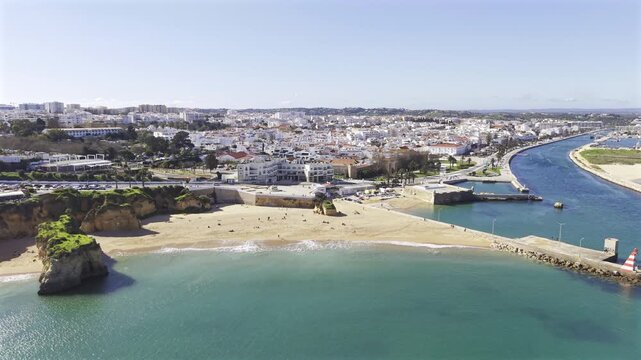 Lagos, Portugal stock HDR drone video - Aerial footage of famous Portuguese city in Algarve with view of Praia da Batata, Rio Bensafrim and the old town area on sunny day in winter.