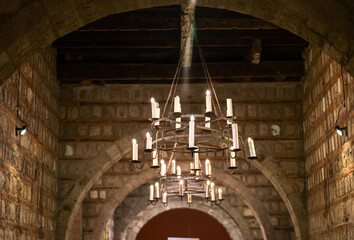 Medieval Style Candle Chandeliers in Historic Stone Hallway © Cherish