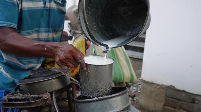 Fresh cow milk pouring into metal container