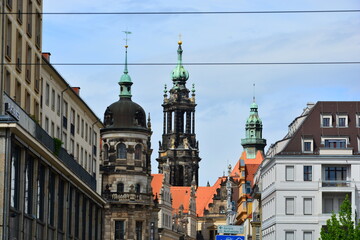 Obraz premium Panorama of historical domes and towers, tightly framed between modern city facades under a blue sky