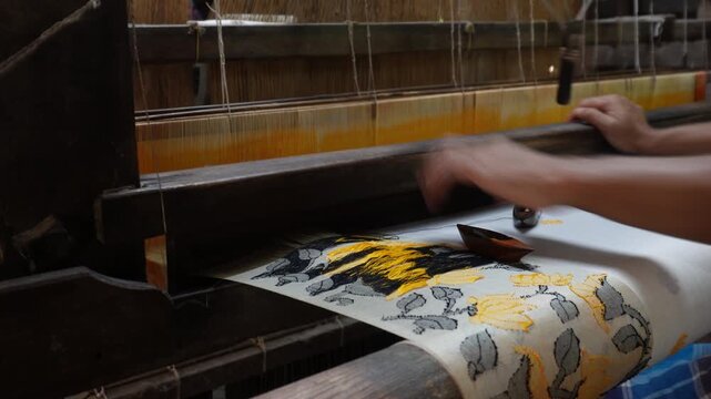 Artisan weaving intricate textile patterns on handloom