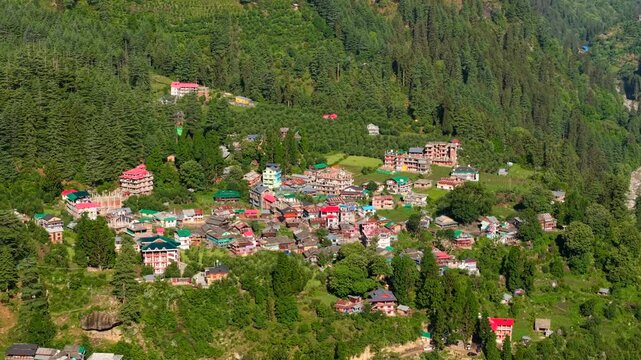Wide drone view of Grahan Village surrounded by forests and mountains in Parvati Valley, near Sar Pass Trek, Kasol, Himachal Pradesh, India.