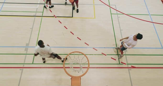 Diverse male friends dribbling basketball, playing offense, laying up, dunking and scoring