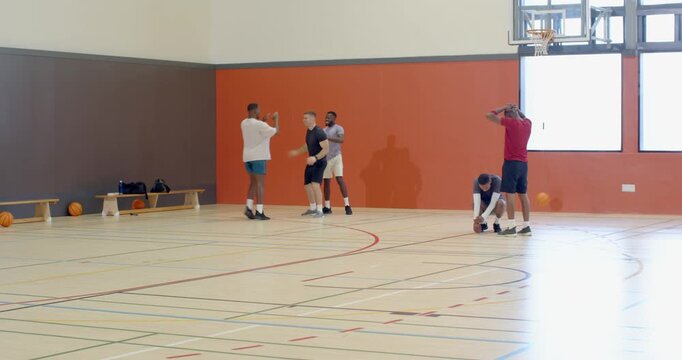 Diverse male friends dunking basketball, embracing, walking off court, copy space