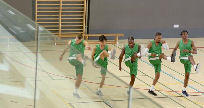 Start prompting five male basketball players warming up, lifting, marching, pivoting at court