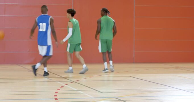 Dribbling crossover male players beating defender to set up shot passing ball, laughing midcourt