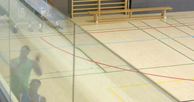 Defender pressuring african american male faking drive, crossing over ball on gym court for shot