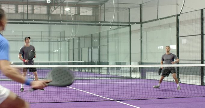 Ball arcing on court, african american man hitting volley winning point and meeting partner at net