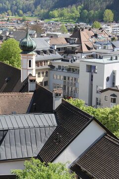 High angle view of the historic Auracher Turm tower with red tiled rooftops, traditional alpine architecture and urban buildings in the old town of Kufstein, Tyrol, Austria.