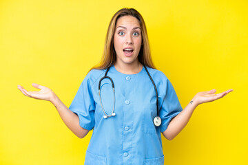 Young surgeon nurse woman isolated on yellow background with shocked facial expression