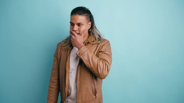 Young man with long hair showing a wide range of negative emotions, from disbelief and confusion to pure shock against a plain background