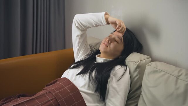 Fatigue young woman experiencing headache cephalalgia, pain with fatigue lying in couch sofa, unhealthy female suffering sick and coughing, illness virus spread for infection, sinus and cold symptoms