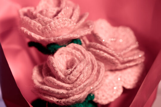 Handmade crochet pink blossoms on bold red background
