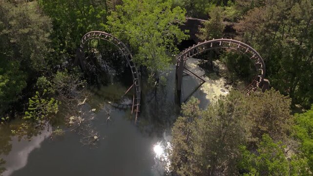 Drone view of an abandoned roller coaster flooded in forest